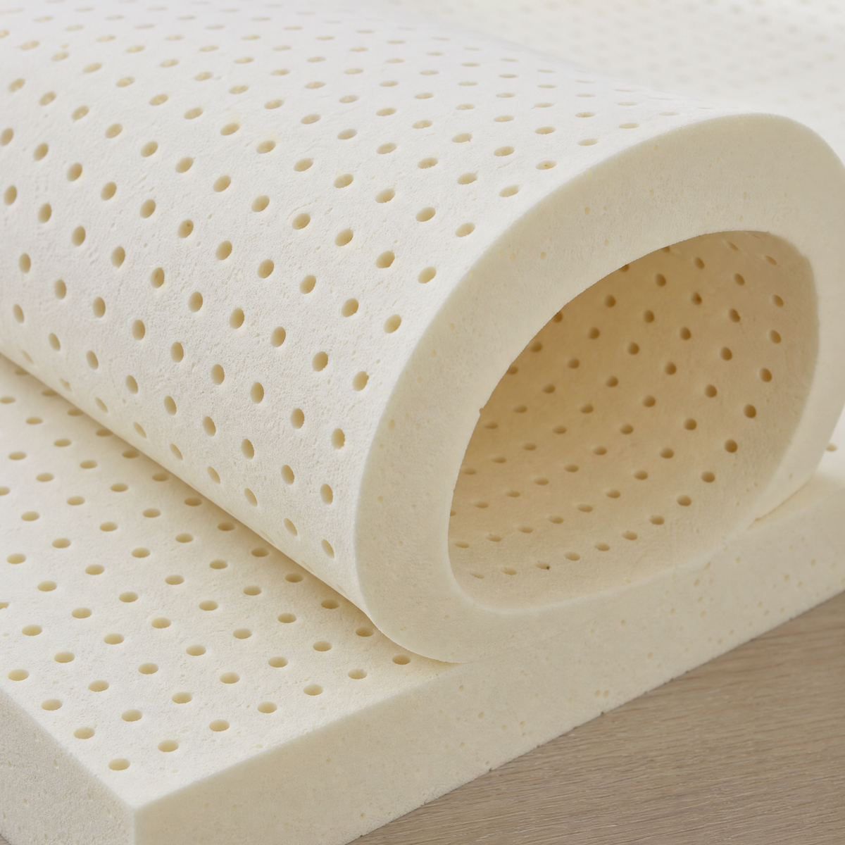 A sheet of latex flexed by hand, showing the open pincore channels running through the block