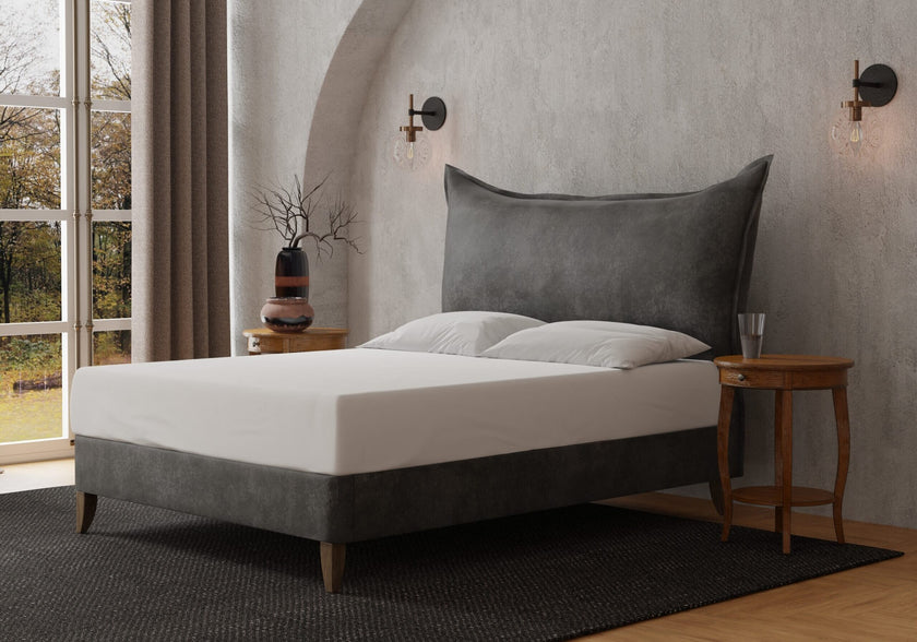 The Berkley Upholstered Bed resembling a large pillow with a French lunar seam, also available as a headboard-only option