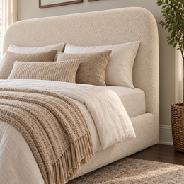 Close up of the Ascot King 5'0 arched headboard and ottoman base upholstered in Teddy Boucle Cream